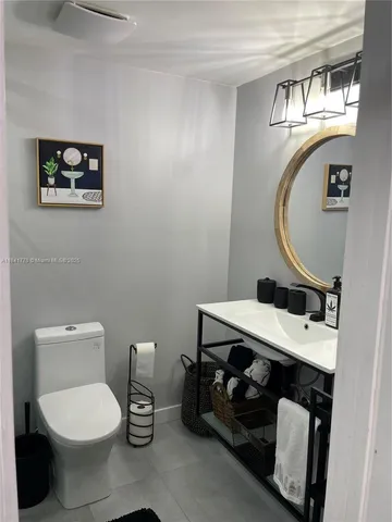 a bathroom with a toilet a sink and mirror