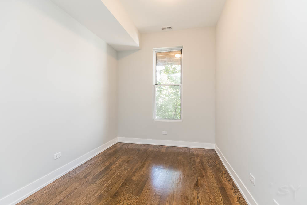 2228 West Cermak Road Chicago, IL 60608 - Photo 11 of 32 an empty room with wooden floor and windows