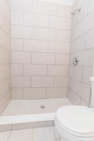 a white toilet sitting next to a bath tub