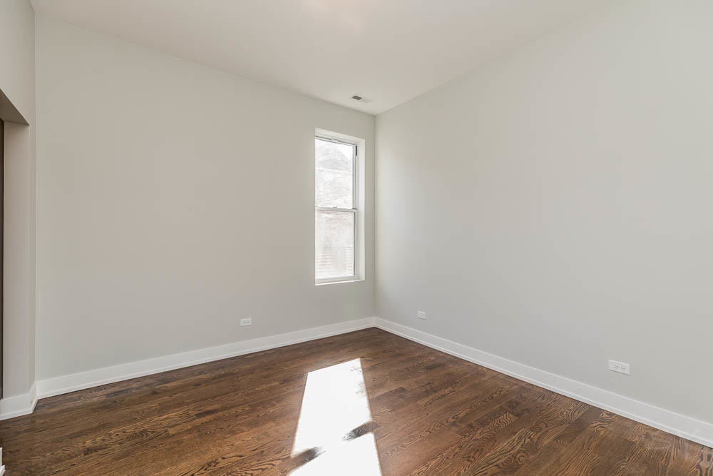 2228 West Cermak Road Chicago, IL 60608 - Photo 19 of 32 an empty room with wooden floor and windows