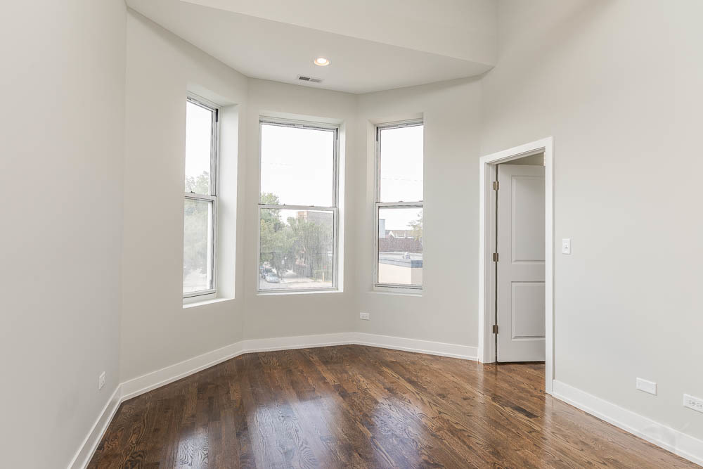2228 West Cermak Road Chicago, IL 60608 - Photo 6 of 32 an empty room with wooden floor and windows