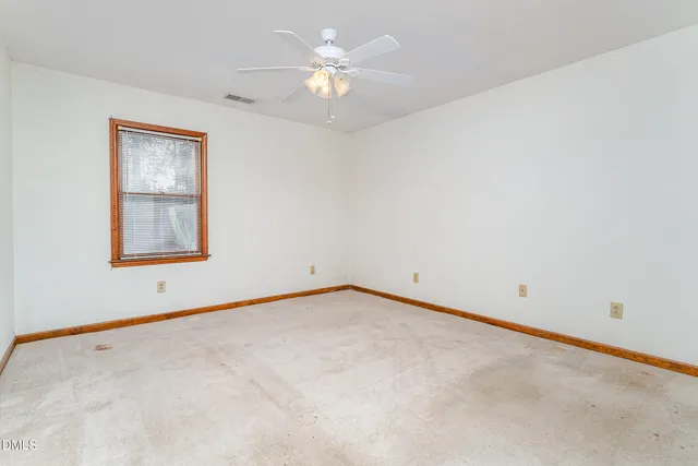 a view of an empty room with a ceiling fan
