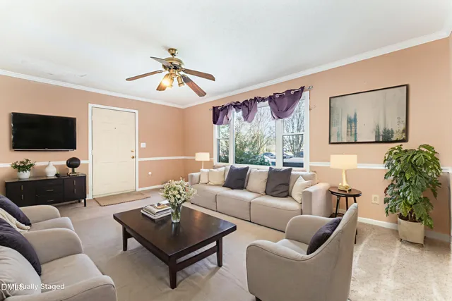 a living room with furniture a flat screen tv and a chandelier