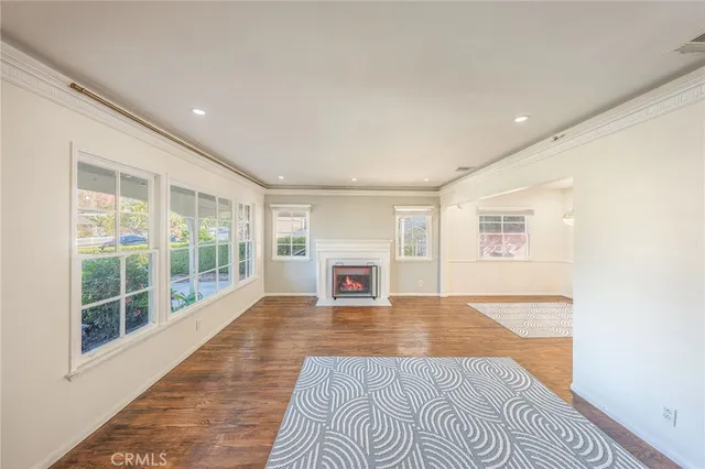 a view of a livingroom with wooden floor and a fireplace