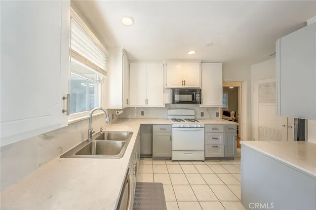 a kitchen with a sink a stove a microwave and cabinets