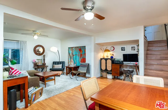 a living room with furniture a clock and a large window