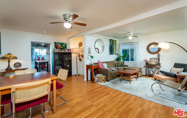 a room with stainless steel appliances a dining table and chairs in it