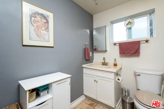 a living room with furniture a flat screen tv and a refrigerator
