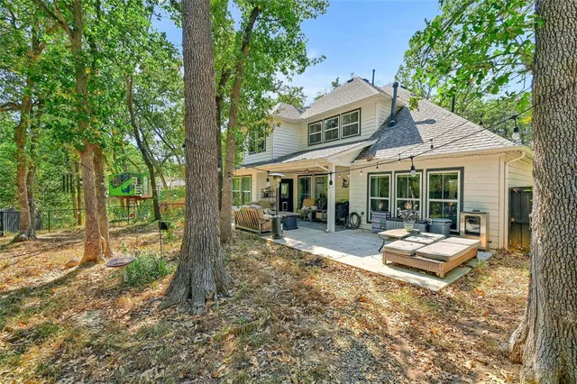 a outdoor space with patio the couches and a dining table with large trees