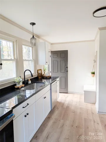 a large kitchen with granite countertop a sink stainless steel appliances and cabinets