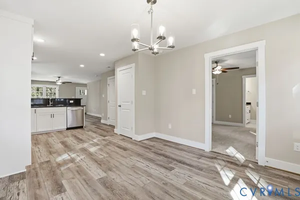 a view of kitchen with granite countertop cabinets and chandelier