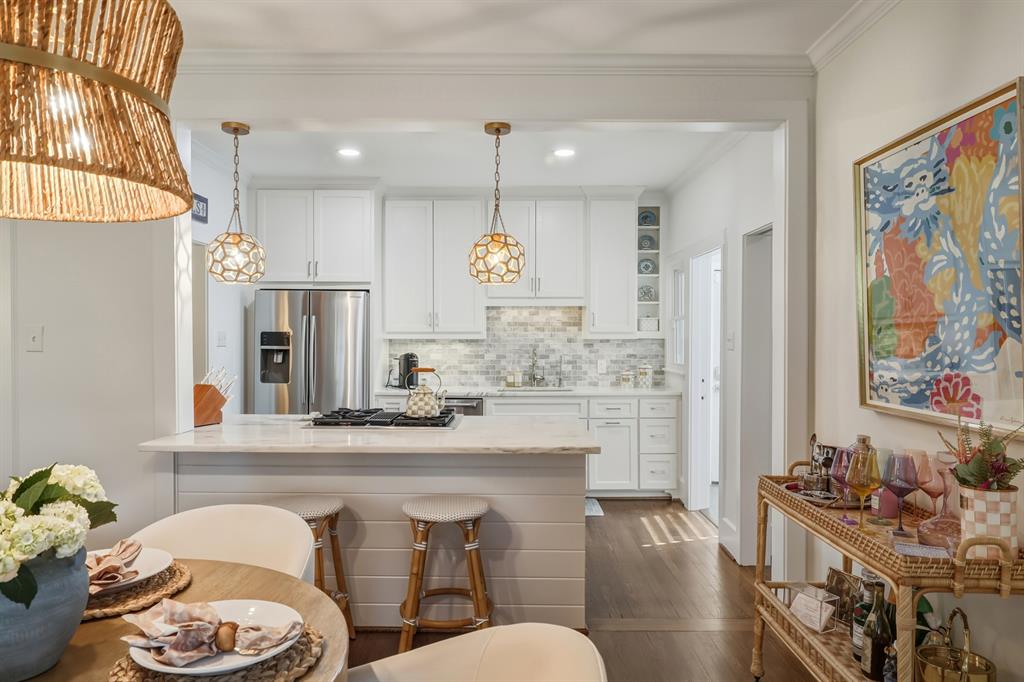 5250 Goodwin Avenue Dallas, TX 75206 - Photo 11 of 33 a kitchen with stainless steel appliances kitchen island granite countertop a refrigerator a sink a stove and white cabinets with wooden floor