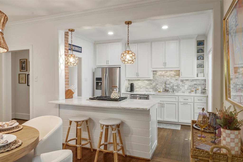5250 Goodwin Avenue Dallas, TX 75206 - Photo 12 of 33 a kitchen with stainless steel appliances granite countertop a kitchen island a stove a table and chairs in it