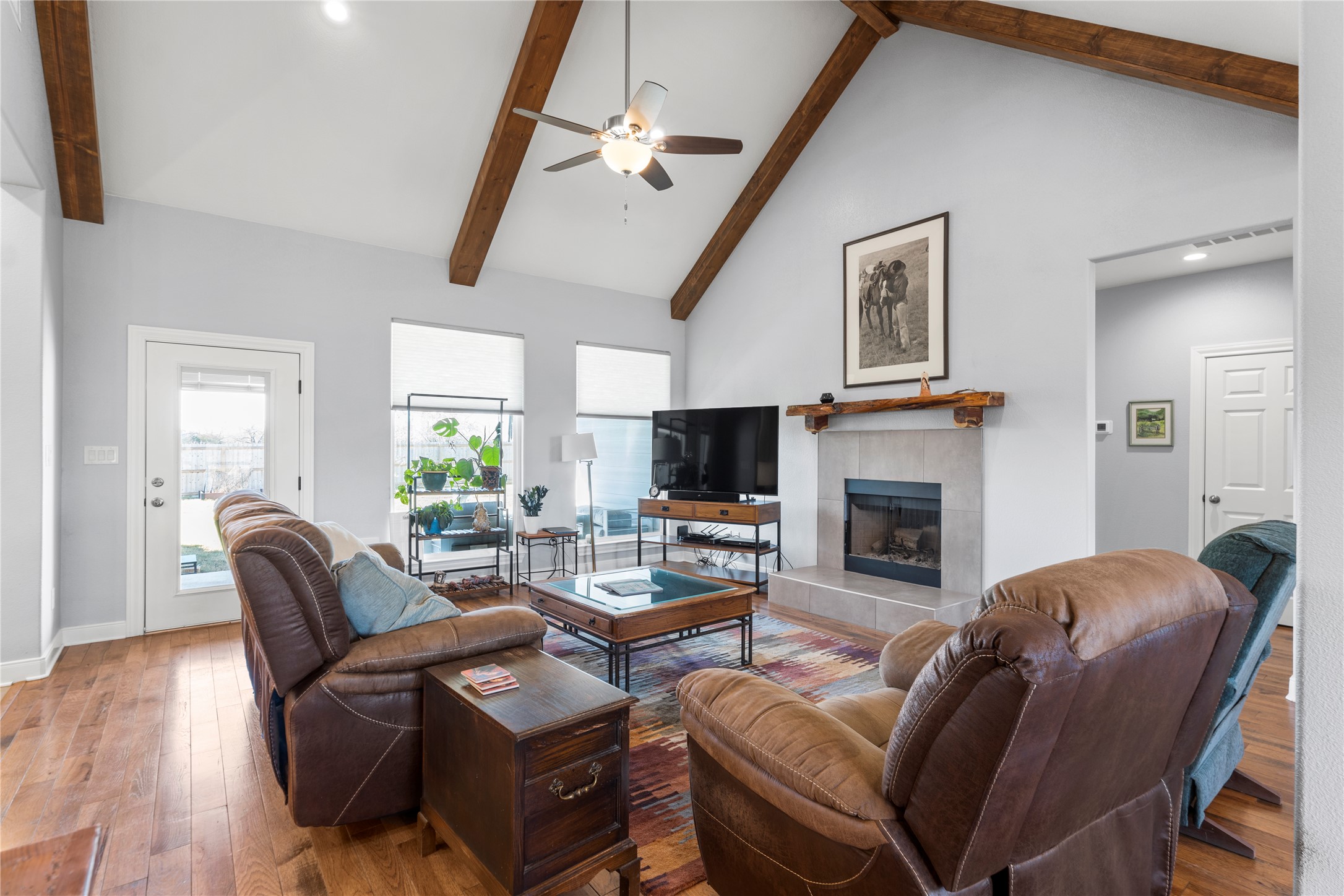 1434 Antioch Road Paige, TX 78659 - Photo 13 of 40 Living area featuring oak- wood- flooring, ceiling fan, tile fireplace, lofted ceiling, and plenty of natural light