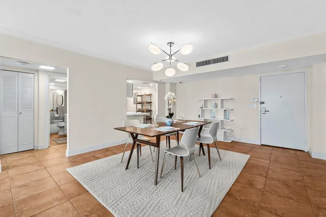 a dining room with wooden floor a chandelier a wooden table and chairs