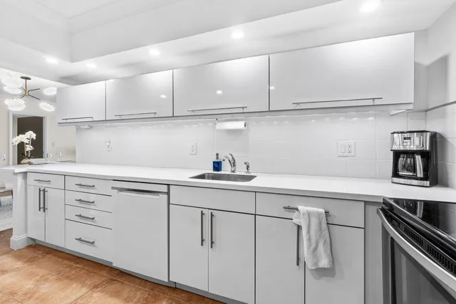 a kitchen with white cabinets stainless steel appliances and sink