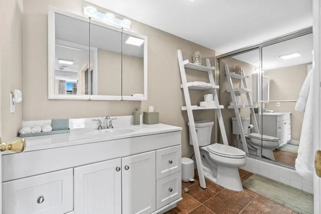 a bathroom with a sink a toilet and a mirror