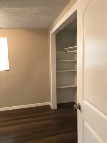 a view of a room with wooden floor and a window