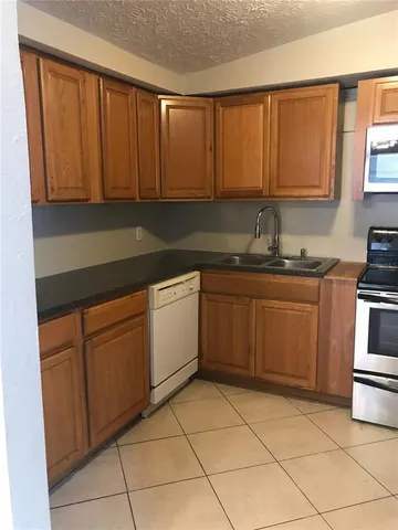 a kitchen with a sink dishwasher stove and cabinets