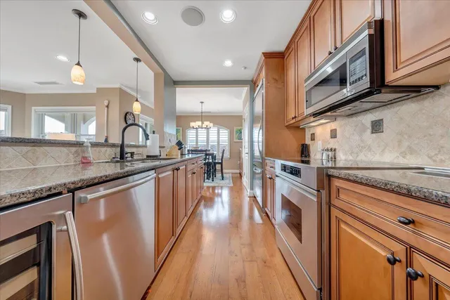 a kitchen with counter top space a sink wooden floor and stainless steel appliances