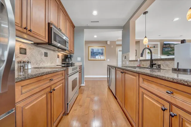 a large kitchen with stainless steel appliances granite countertop a lot of counter space and a sink