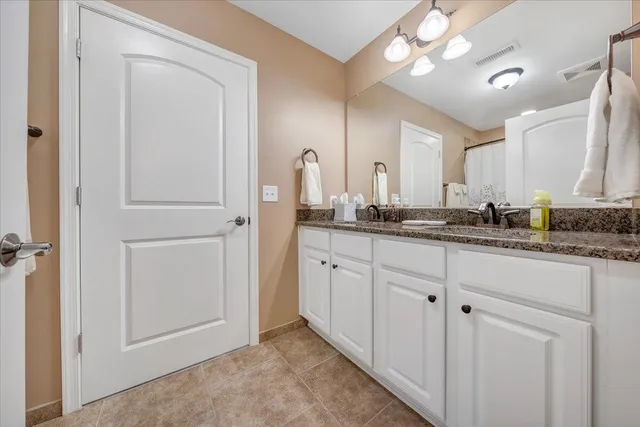 a bathroom with a granite countertop sink and a mirror