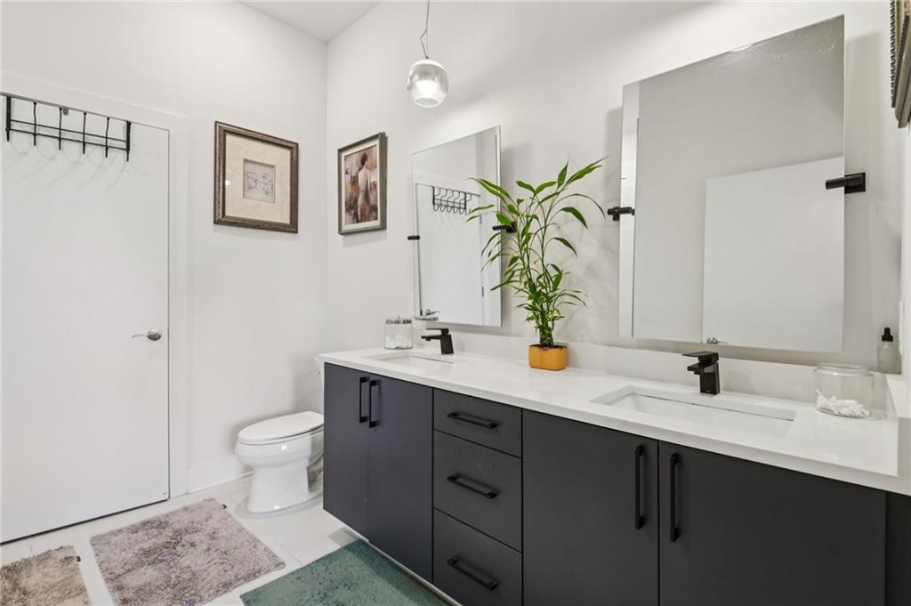 112 Rogers Street Northeast, Unit 409 Atlanta, GA 30317 - Photo 11 of 18 a bathroom with a double vanity sink toilet and a mirror