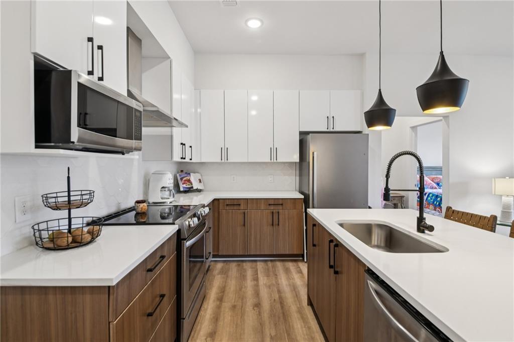 112 Rogers Street Northeast, Unit 409 Atlanta, GA 30317 - Photo 3 of 18 a kitchen with a sink a stove and cabinets