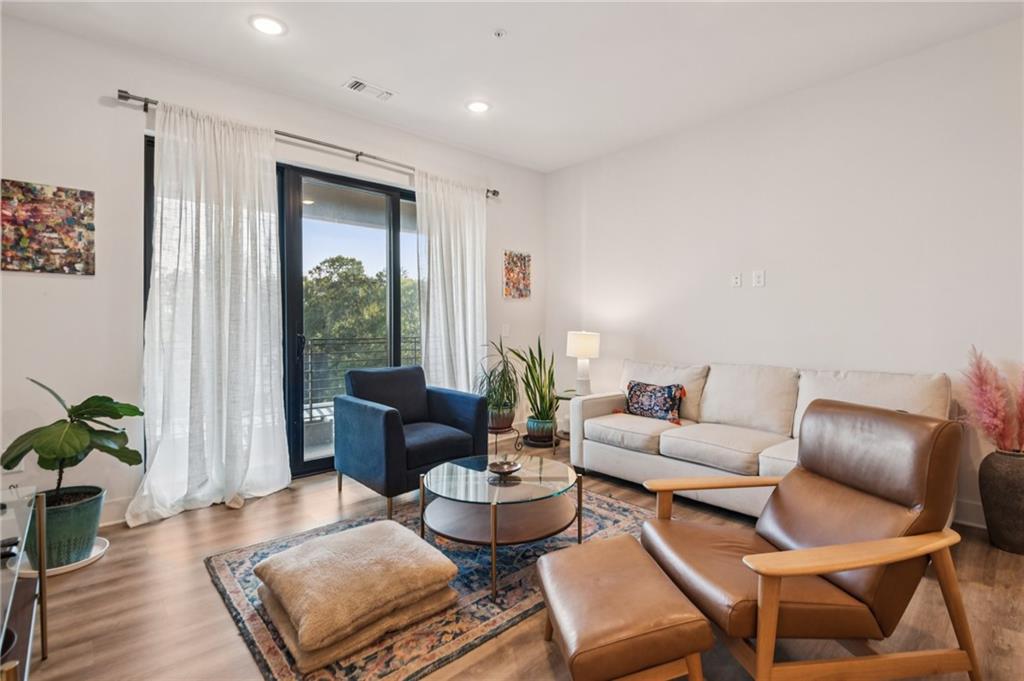 112 Rogers Street Northeast, Unit 409 Atlanta, GA 30317 - Photo 5 of 18 a living room with furniture and a large window