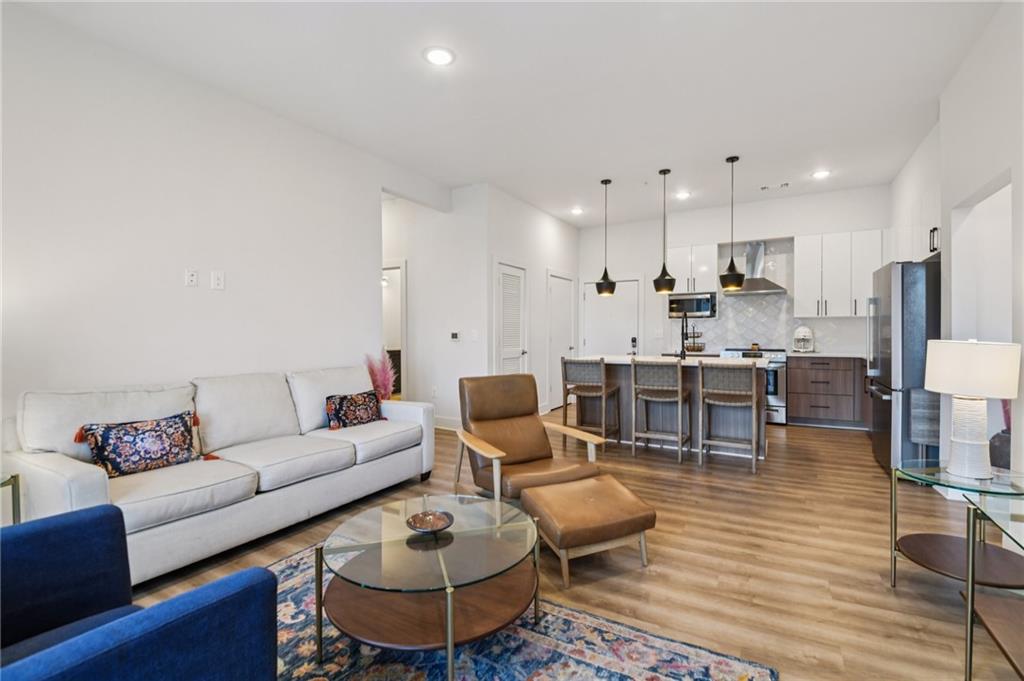 112 Rogers Street Northeast, Unit 409 Atlanta, GA 30317 - Photo 6 of 18 a living room with furniture and kitchen view