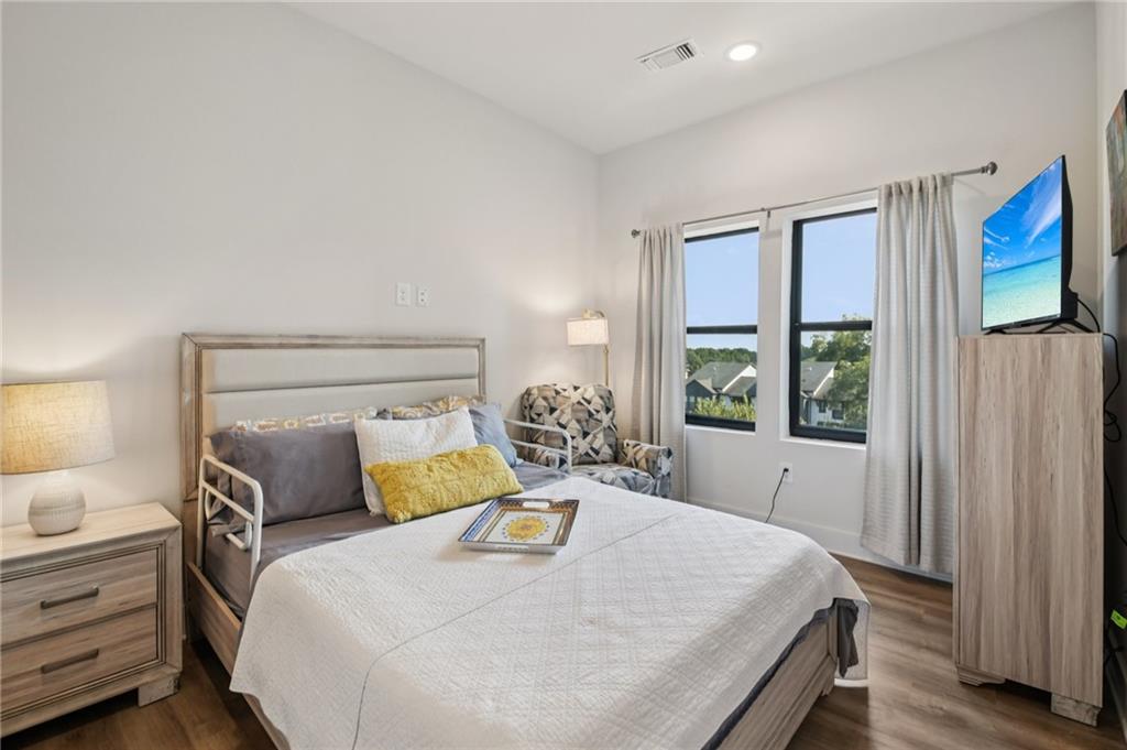 112 Rogers Street Northeast, Unit 409 Atlanta, GA 30317 - Photo 8 of 18 a bedroom with a bed and a window