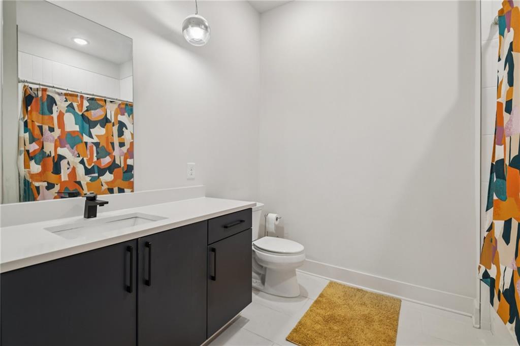 112 Rogers Street Northeast, Unit 409 Atlanta, GA 30317 - Photo 9 of 18 a bathroom with a sink a toilet and mirror