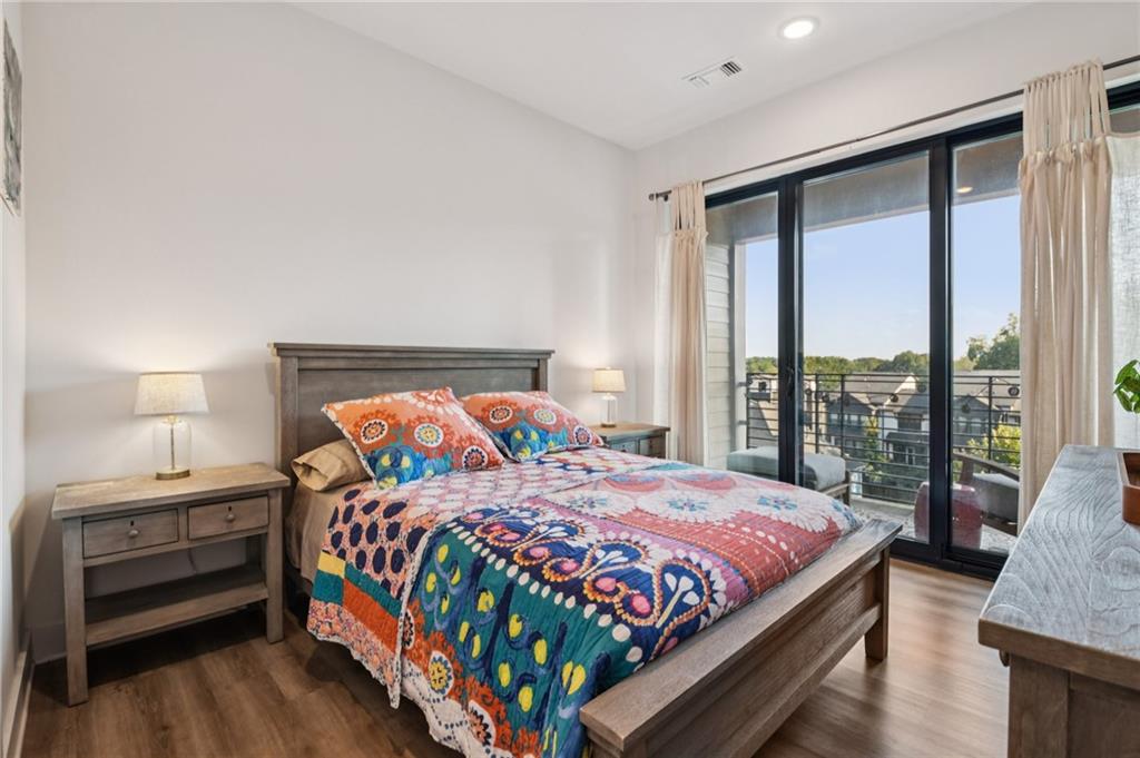 112 Rogers Street Northeast, Unit 409 Atlanta, GA 30317 - Photo 10 of 18 a bedroom with a bed and a large window
