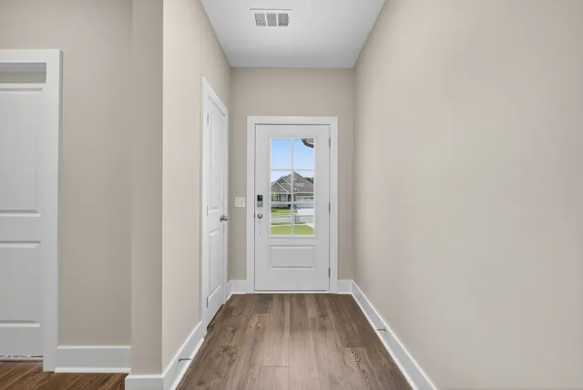 a view of a hallway with wooden floor