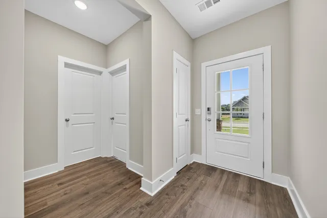 an empty room with wooden floor and windows