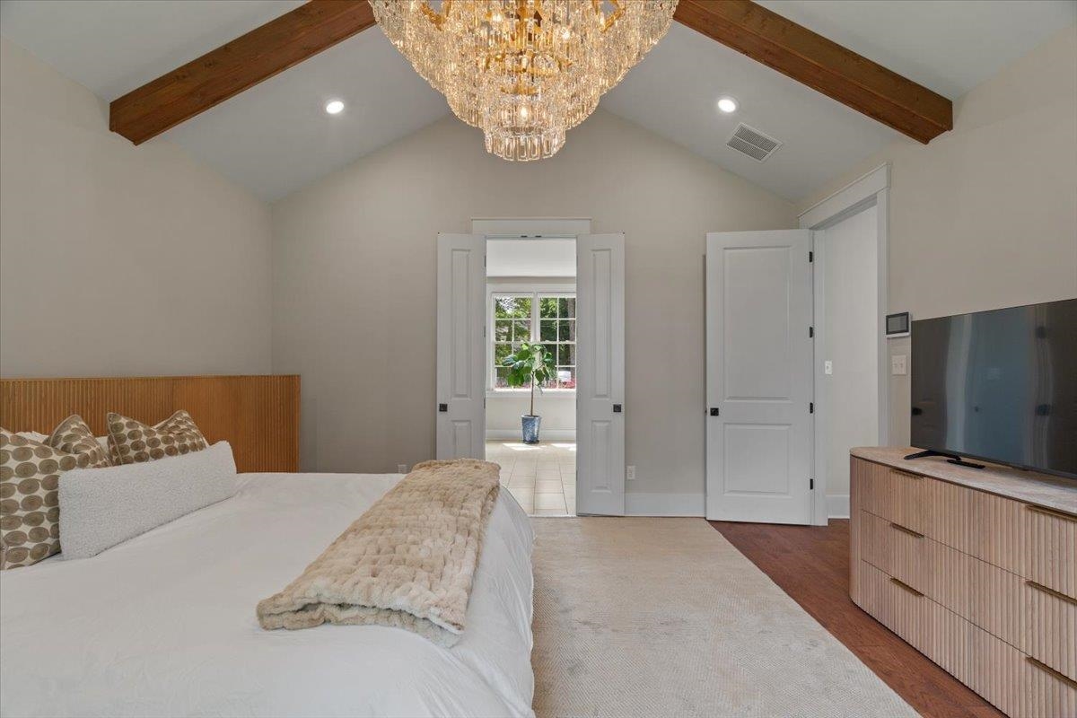 240 Burrows Road Collierville, TN 38017 - Photo 13 of 37 Vaulted ceiling featuring exposed wood beams and a large crystal chandelier