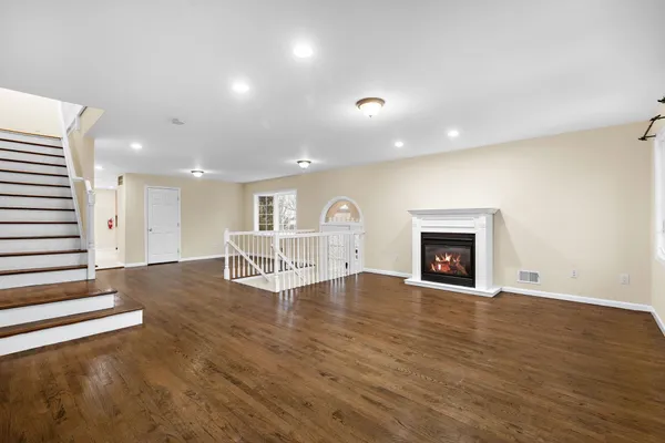 an empty room with wooden floor and fireplace