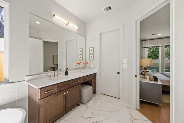 a spacious bathroom with a double vanity sink a mirror and a shower