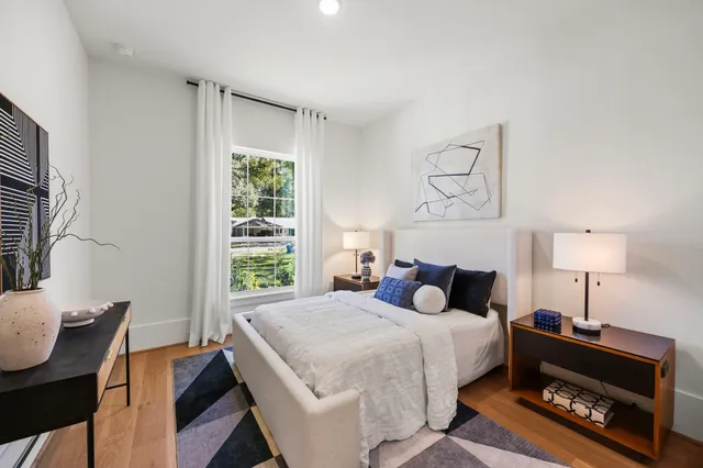 a bedroom with a bed a dresser and window