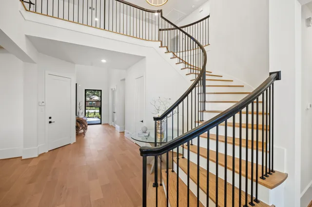 a view of staircase with railing and white walls