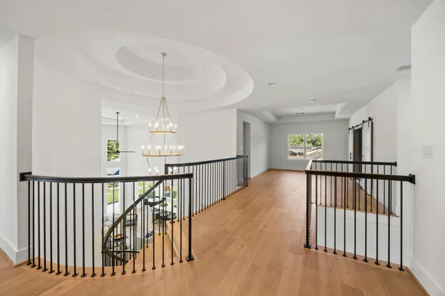 a view of staircase with railing and a chandelier
