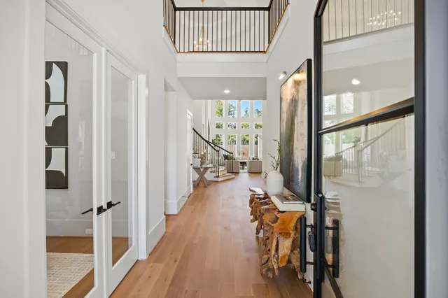 a view of a hallway with wooden floor and windows