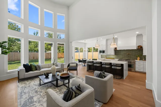 a living room with fireplace furniture and a kitchen view