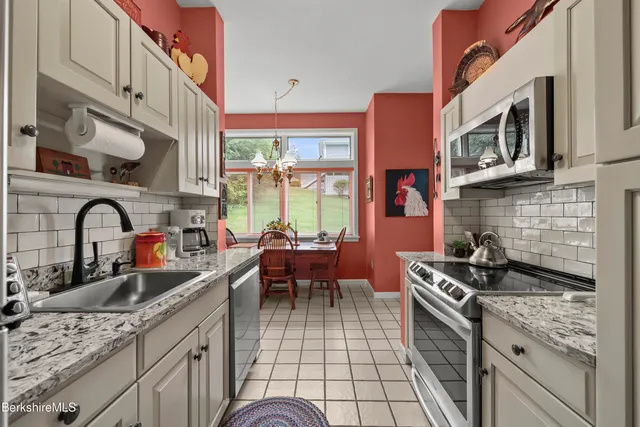a kitchen with stainless steel appliances granite countertop a stove a sink dishwasher and cabinets with wooden floor