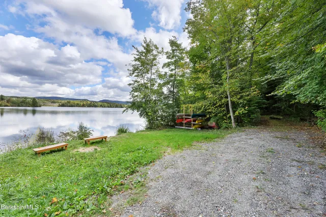 a backyard of a house with lots of green space and lake view