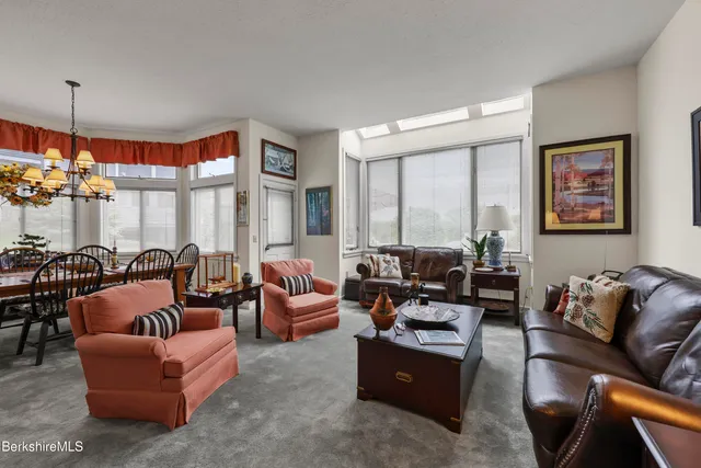 a living room with furniture fireplace and large windows