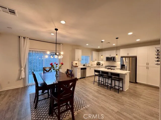 a kitchen with kitchen island granite countertop a sink a counter and stainless steel appliances