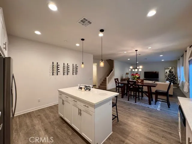 a kitchen with stainless steel appliances kitchen island granite countertop a kitchen island hardwood floor sink and stove