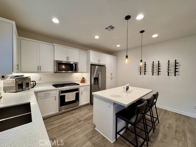 30411 Ridgecrest Road Winchester, CA 92596 - Photo 17 of 46 a kitchen with stainless steel appliances kitchen island granite countertop a kitchen island hardwood floor sink and stove