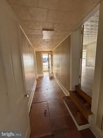 a view of a hallway to rooms and stairs